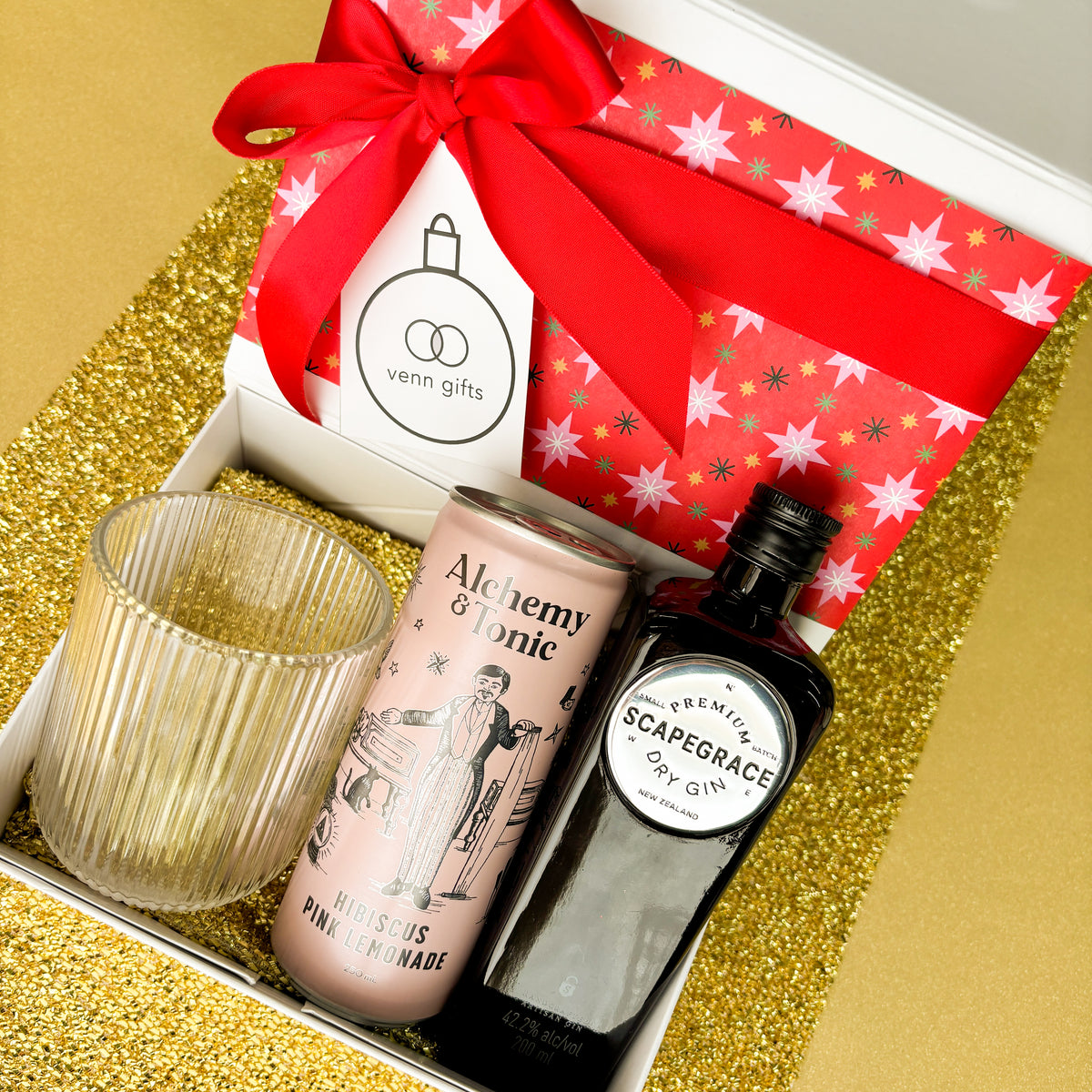 Scapegrace gin, reeded glass and alchemy & tonic hibiscus lemonade presented in front of a white gift box with a red ribbon by Venn Gifts.