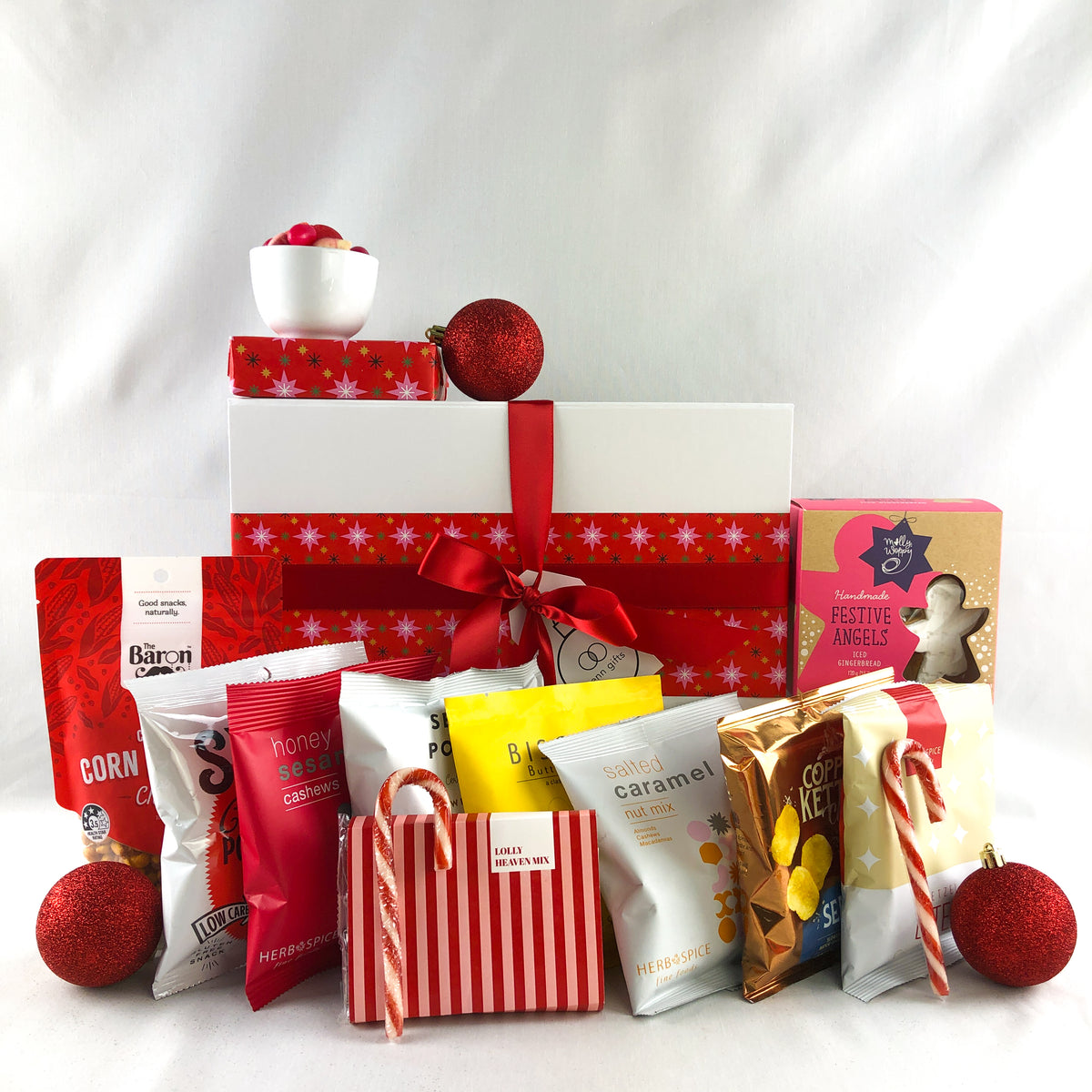 red and gold snacks festive themed in front of a white giftbox with red ribbon by Venn Gifts