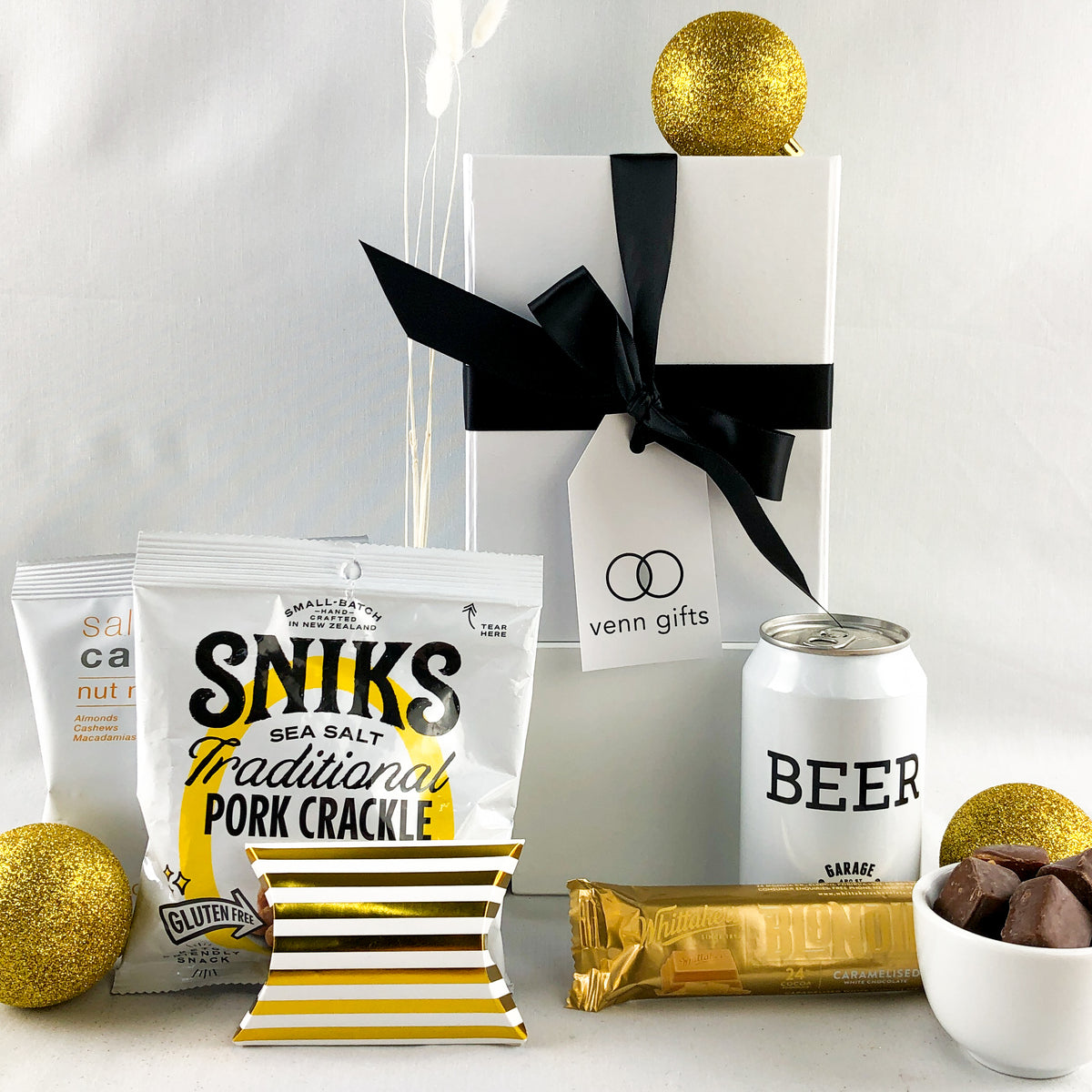 Garage Project beer and snacks with chocolate in front of a white gift box with a black ribbon by Venn Gifts.