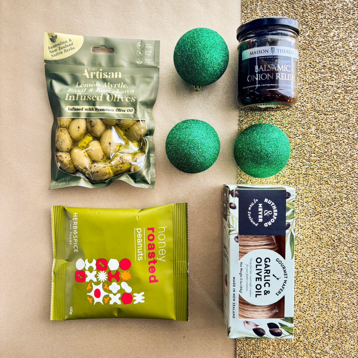 Flatlay of savoury snacks and relish on a gold background by Venn Gifts