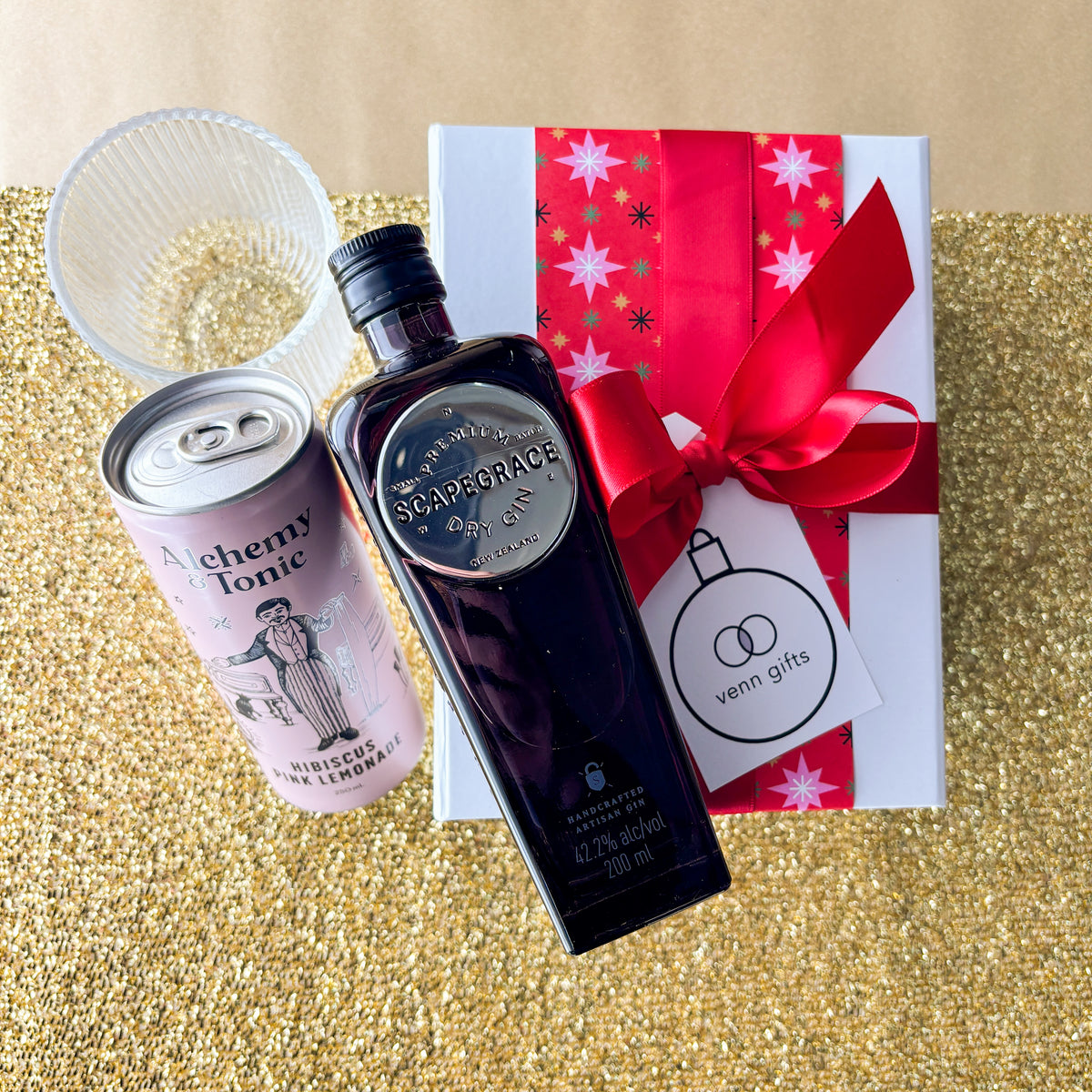 Scapegrace gin, reeded glass and alchemy & tonic hibiscus lemonade presented in front of a white gift box with a red ribbon by Venn Gifts.